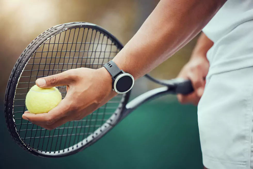 Nahaufnahme eines Tennisspielers mit Tennisschläger und Ball, der sich bereit für den Aufschlag macht